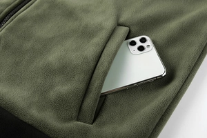 Detailed macro view showing soft olive green polar fleece texture and functional zipper pocket
