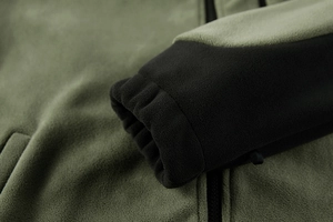 Detailed macro view of olive green fleece jacket with elastic black cuffs and soft texture