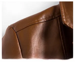 Macro shot of brown PU leather jacket shoulder seams and natural grain texture
