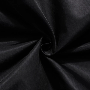 Dettaglio del tessuto in nylon nero ad alta densità con trama diagonale fine sulla giacca