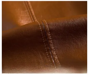 Detailed macro view of premium brown sheepskin leather with professional double stitching