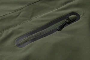 Macro-opname van de waterdichte rits met naadafdichting op het legergroene outdoorjack
