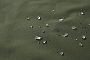 Detailopname van waterdichte olijfgroene stof met waterdruppels op het oppervlak