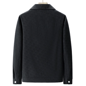 Détail d'une veste noire pour homme avec tissu jacquard à logo et bouton de manchette argenté