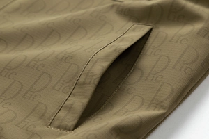 Détail du tissu ripstop kaki de la veste avec motif imprimé intégral de lettres Dlic