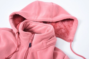 Dettaglio macro della felpa rosa in pile che mostra la fodera calda e la zip del collo