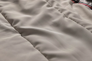 Macro della fodera trapuntata beige che mostra la texture liscia e l'imbottitura