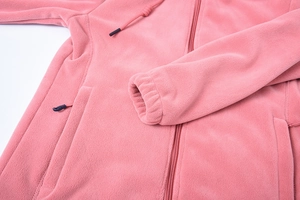 Dettaglio della giacca in pile rosa con trama del tessuto calda e coulisse regolabile