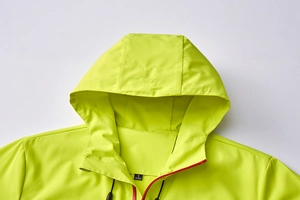 Close-up of lightweight yellow outdoor jacket with red contrast zipper and hooded collar