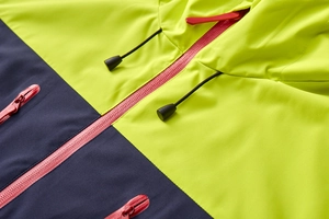 Detail of outdoor jacket with waterproof red zippers and neon yellow navy splicing