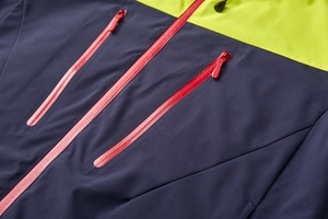 Detail of waterproof taped zippers and contrast stitching on blue outdoor hiking jacket
