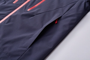 Detailed macro view of the waterproof orange zipper on a dark blue hiking jacket