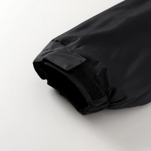 Dettaglio del polsino regolabile in velcro e del design elastico della giacca nera