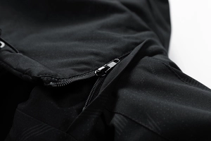 Makrodetail eines hochwertigen Metallreißverschlusses an einer schwarzen Outdoorjacke