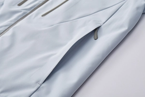 Close-up of waterproof zipper pocket on light blue men's mountain hiking jacket
