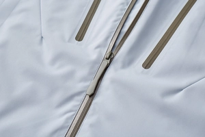 Detail shot of waterproof taped zippers and technical fabric on men's outdoor mountain jacket