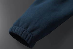 Detailed macro view of dark blue fleece jacket cuff with elastic ribbed hem finish
