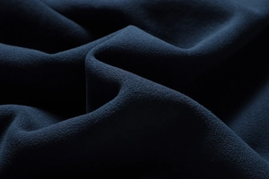 Close-up of thick navy blue fleece fabric showing soft grain texture and warm material