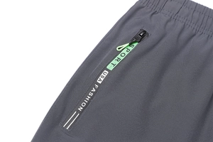 Dettaglio dell'elastico in vita e tasca con zip su pantaloni cargo grigio scuro sportivi