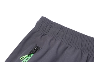 Dettaglio dell'elastico in vita e tasca con zip grigio scuro con cordino verde