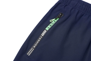 Vista dettagliata dei pantaloni sportivi blu navy ad asciugatura rapida con tasca neon