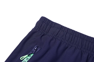 Dettaglio vita elastica e tasca con cerniera e tirante verde su pantaloni cargo
