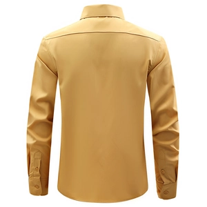 Detail of mustard yellow men's shirt showing silky texture and buttoned cuffs