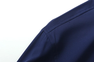 Dettaglio delle cuciture rinforzate sulla spalla e del tessuto blu scuro della camicia