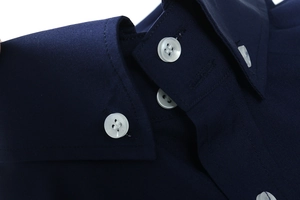 Dettaglio del colletto button-down blu scuro con bottoni bianchi e cuciture sulla camicia