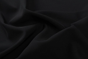 Dettaglio macro del tessuto nero elasticizzato con trama fine e drappeggio elegante