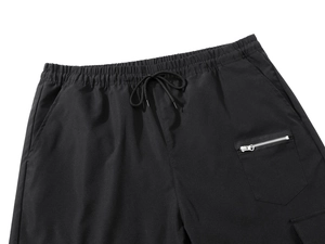 Detail of men's black athletic pants featuring elastic drawstring waist and cargo pockets