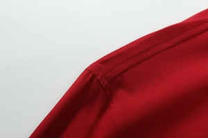 Dettaglio della cucitura piatta di qualità sulla camicia elasticizzata da uomo rosso scuro