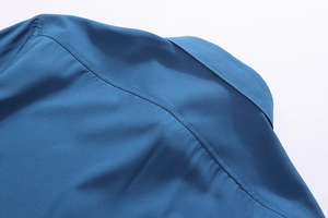 Detailed view of dark blue shirt shoulder stitching and premium woven fabric texture