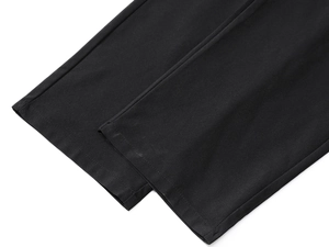 Close-up of high-density woven fabric and neat flat-seam stitching on black athletic pants