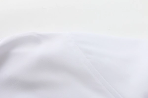 Dettaglio delle cuciture precise e del tessuto liscio di una camicia bianca da uomo