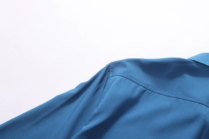 Close-up of shoulder stitching and collar detail on lake blue long-sleeved shirt