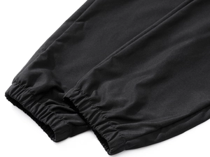 Close-up of elastic ribbed cuffs and stitching details on black joggers for men