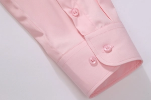 Close-up of pink cotton shirt sleeve with round cuffs and matching resin buttons