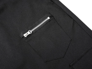 Detail of black tactical joggers showing a durable pentagonal pocket with silver zipper