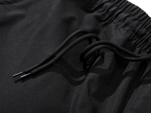 Detailed macro view of black athletic pants featuring elastic waistband and braided drawstring