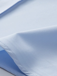 Nahaufnahme der hellblauen Stretchhemd-Stoffstruktur mit präziser Einzelnadel-Naht