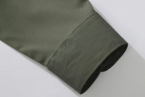 Detailed close-up of olive green shirt cuff showing precise double-stitch craftsmanship