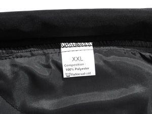 Detail of fabric washing label on black athletic pants with diamond quilted lining