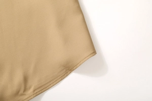 Close-up of the curved hem and fine stitching on this khaki long-sleeve business shirt