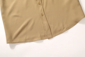 Close-up of khaki business shirt featuring neat button placket and curved hem stitching