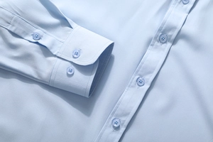 Close-up of light blue shirt cuffs with double button detail and smooth fabric texture