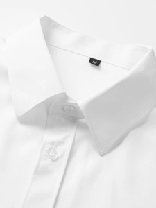 Detailaufnahme des weißen Kurzarmhemd-Kragens mit Knöpfen und dem Größenetikett