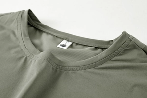 Close-up of the olive green round neckline showing breathable mesh fabric and durable stitching