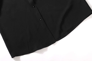 Detail of hidden placket and black buttons on a smooth black business shirt for men