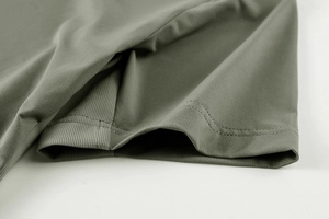 Detailed close-up of olive green breathable fabric with reinforced double stitching